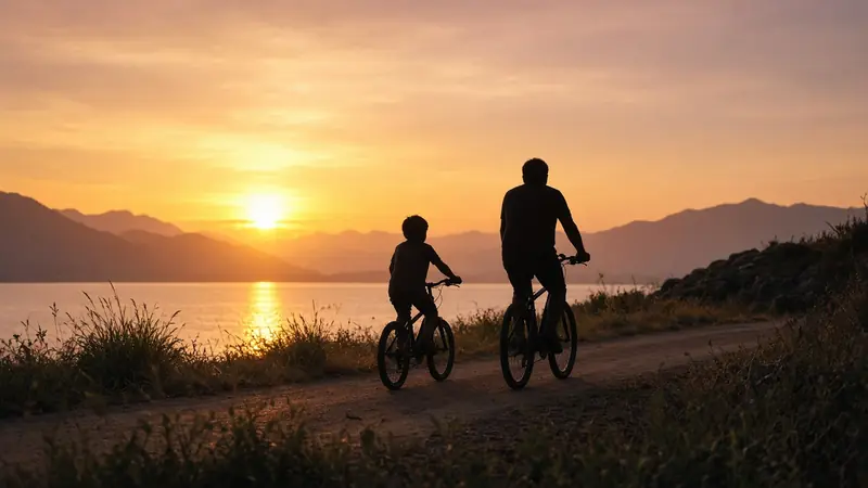 Silhouette of an adult and a child riding bicycles along a path at sunset.